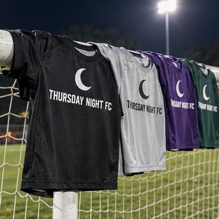 Custom adult league soccer jerseys on a goal post