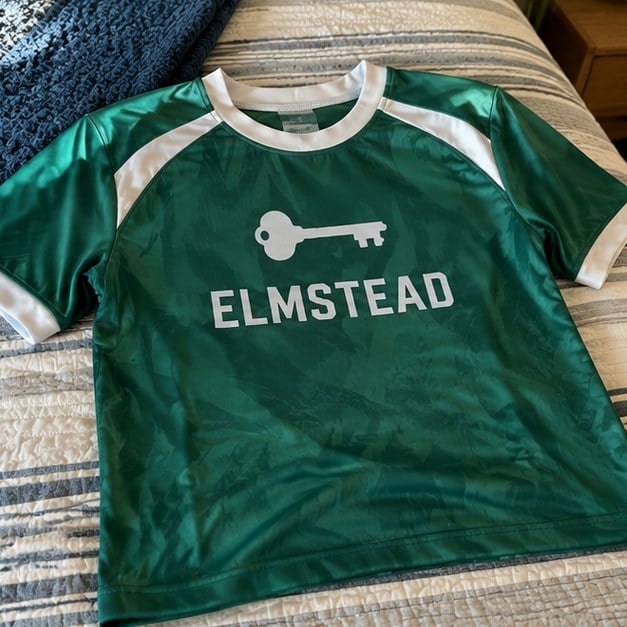 Customer photo of a custom soccer jersey on a bed